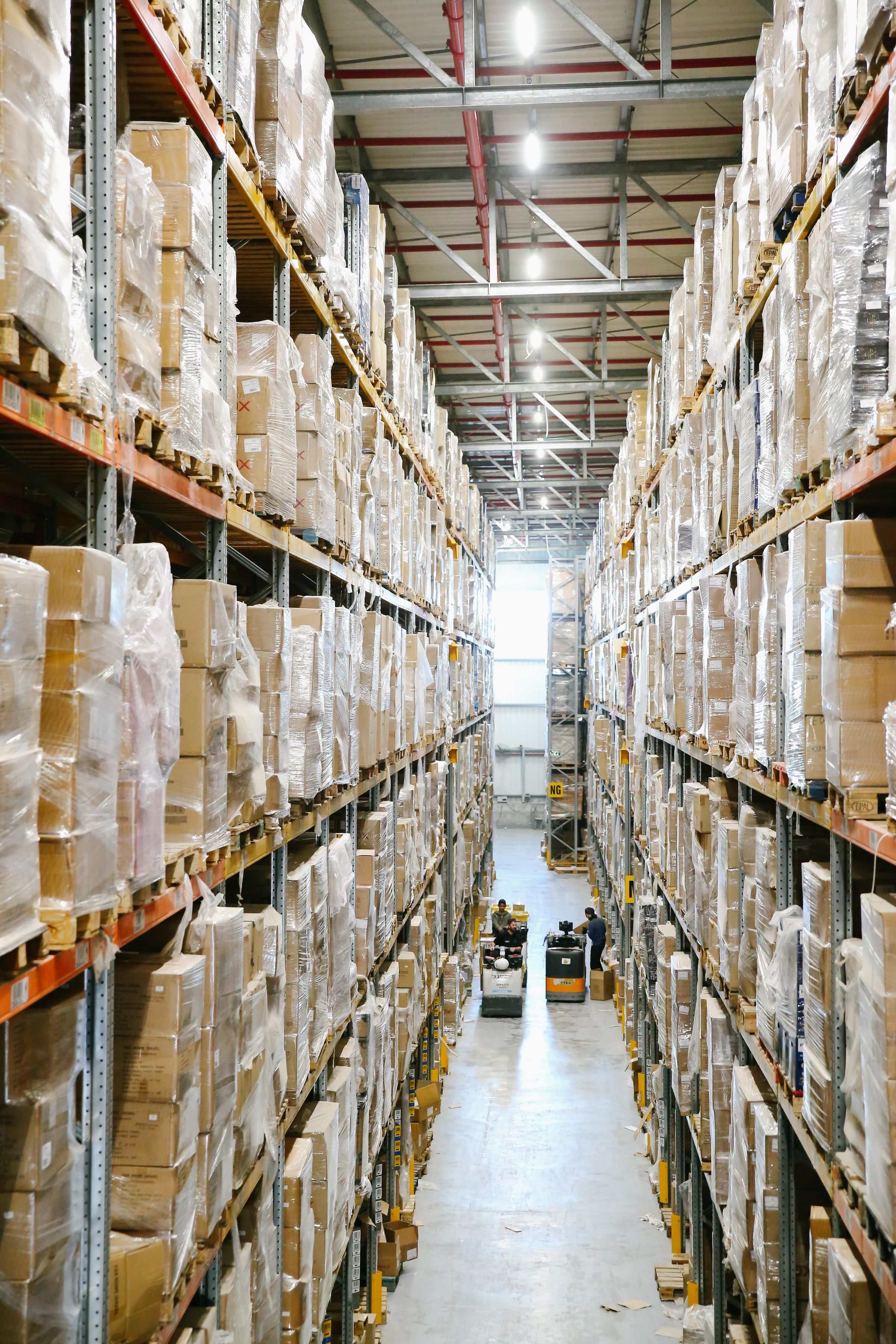 Boxed inventory on shelves in a warehouse aisle